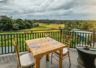 A balcony table overlooking green paddy fields at The Pharo