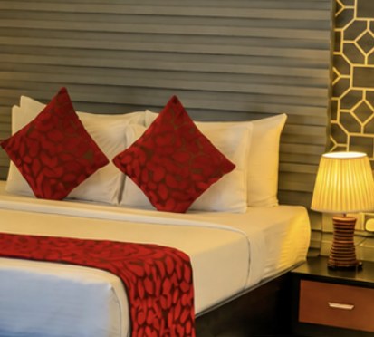 A Pharo bedroom with red cushions and a bedside lamp